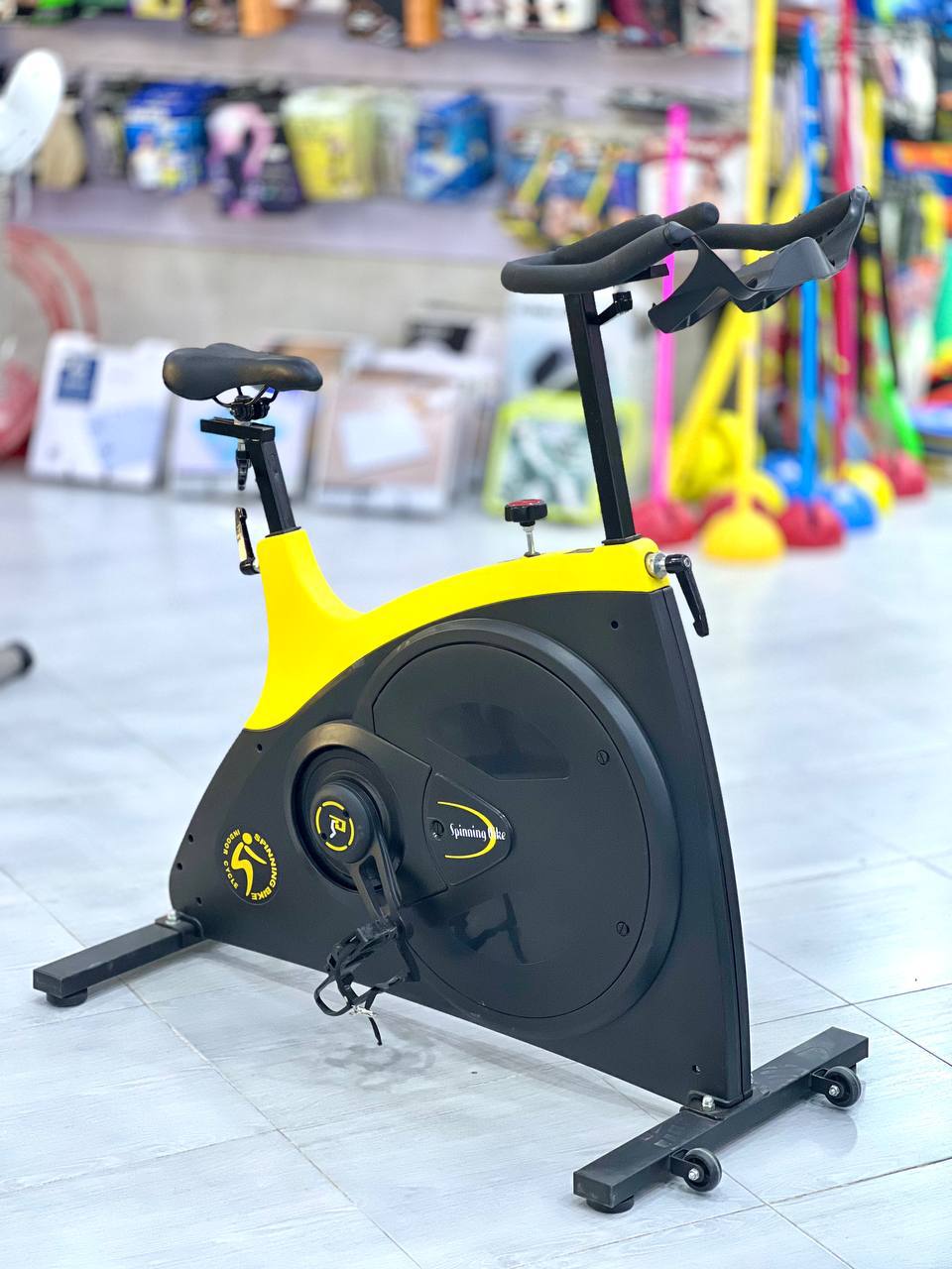 دراجة تمارين داخلية (Spinning Bike) باللونين الأصفر والأسود.